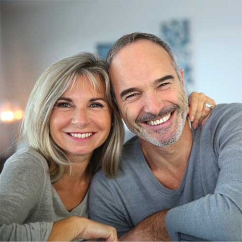 happy adult couple having fun at home after visiting Vilonia Family Dental dental office<br />
