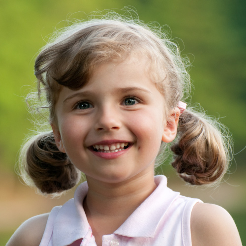 Portrait of adorable smiling little girl outdoor in summer day
